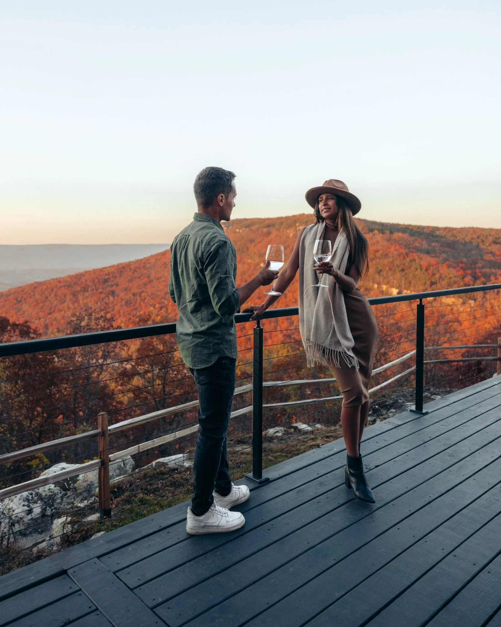 Couple relaxing on the deck at The A-Frame luxury cabin with fall foliage over the Sequatchie Valley