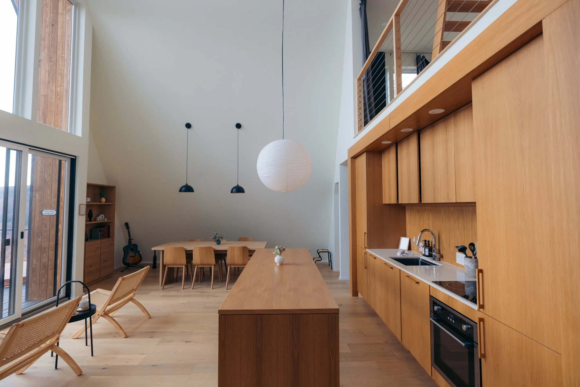 Open-concept luxury cabin interior featuring custom white-oak cabinetry, soaring ceilings, and minimalist modern design at The A-Frame